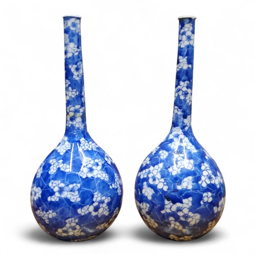 6 - A pair of Chinese bottle vases, painted in tones of underglaze blue with blossoming prunus on a&nbsp... 