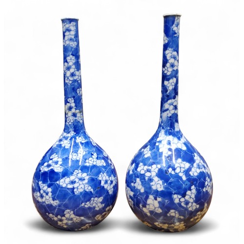 6 - A pair of Chinese bottle vases, painted in tones of underglaze blue with blossoming prunus on a&nbsp... 