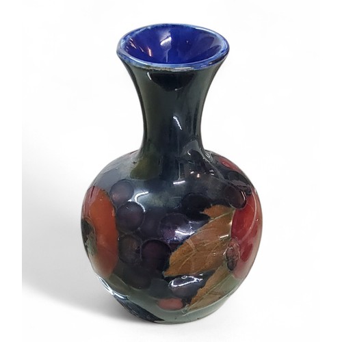 18 - A Moorcroft Pomegranate pattern bottle vase, flared neck,&nbsp; tube lined with fruit and berries, i... 