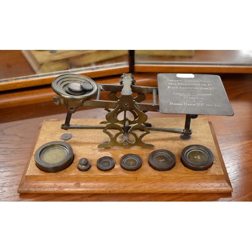 196 - An antique set of brass postage scales on oak base, with weights