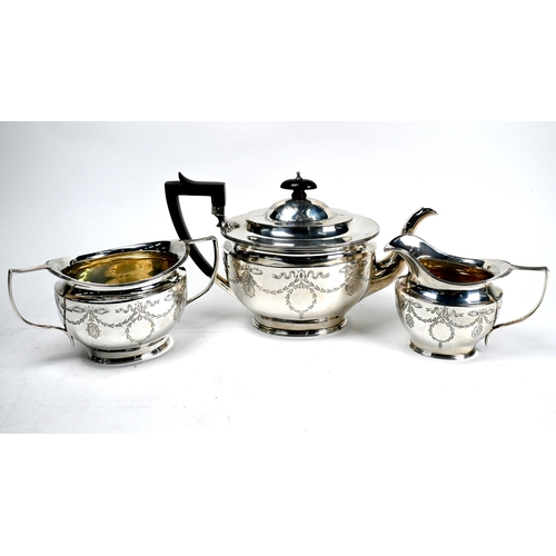 61 - An Edwardian Adam Revival silver three-piece tea service engraved with ribbons and garlands, James D... 