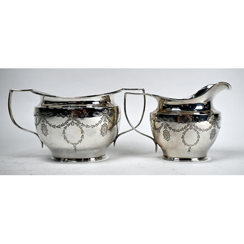 61 - An Edwardian Adam Revival silver three-piece tea service engraved with ribbons and garlands, James D... 