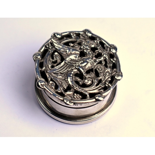 62 - A small cylindrical silver pomander, the pierced cover cast with a gryphon, London 1910, 3.5cm diame... 