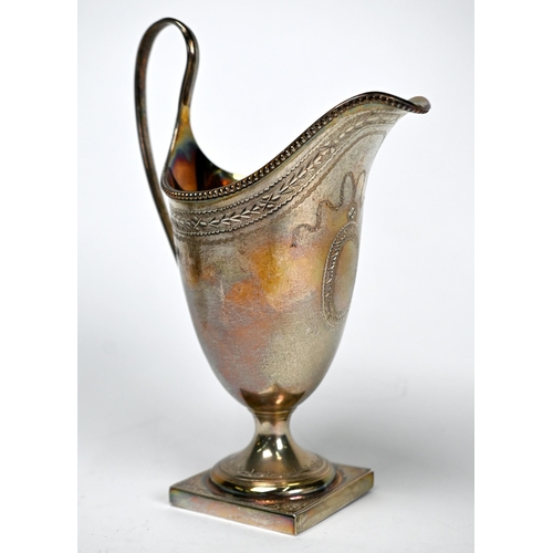 75 - A silver helmet cream jug in the Georgian manner with beaded rim and engraved decoration, on square ... 