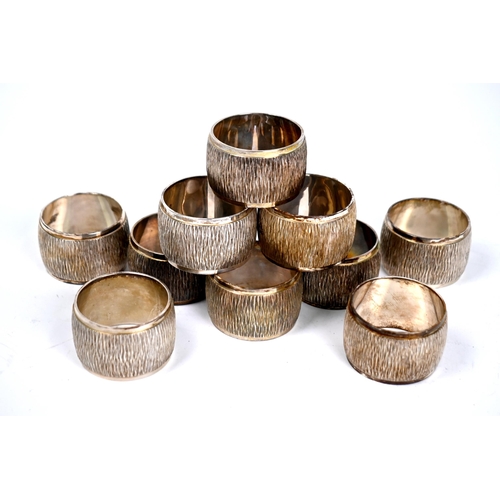 76 - A set of ten heavy quality silver napkin rings with textured decoration,  C.J. Vander Ltd, London Ju... 