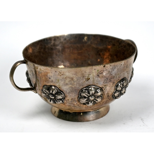 87 - A Continental (probably Indian) low-grade white metal two-handled basin on raised foot-rim, applied ... 