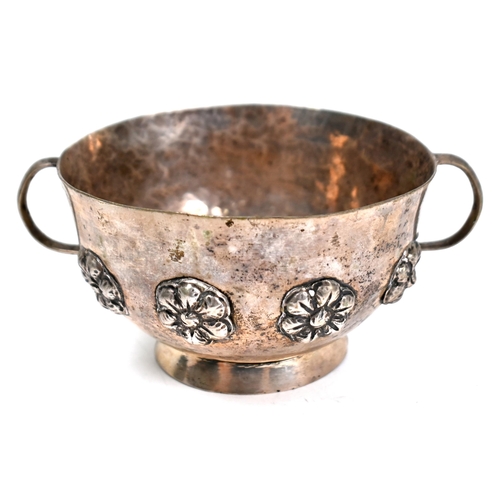 87 - A Continental (probably Indian) low-grade white metal two-handled basin on raised foot-rim, applied ... 