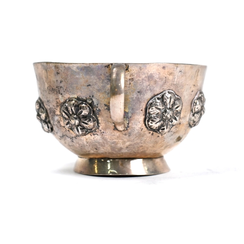 87 - A Continental (probably Indian) low-grade white metal two-handled basin on raised foot-rim, applied ... 