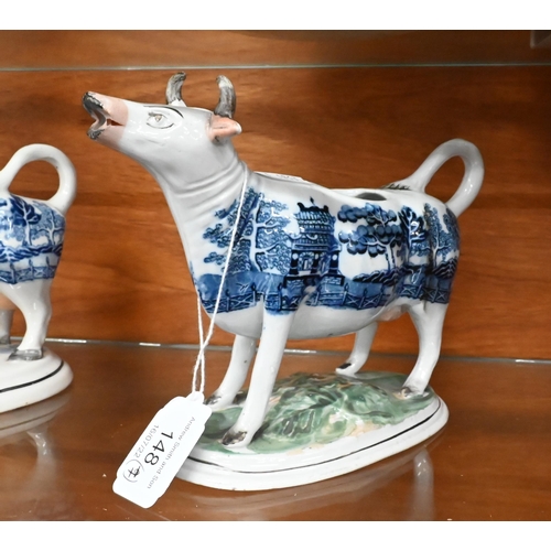 148 - Two early 19th century pearlware Willow pattern cow creamers, to/w a Staffordshire cow and milkmaid ... 