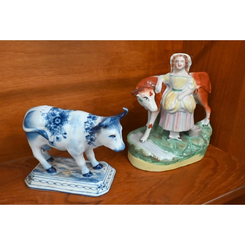 148 - Two early 19th century pearlware Willow pattern cow creamers, to/w a Staffordshire cow and milkmaid ... 