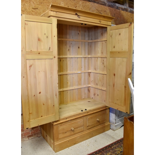 244 - A modern pine wardrobe with a pair of panelled doors over two drawers on plinth base, 120 cm wide x ... 