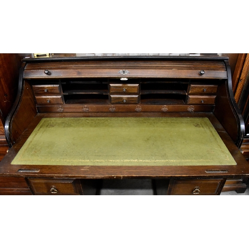 393 - An early 20th century oak roll top desk with sliding tambour panel enclosing fitted interior (locked... 