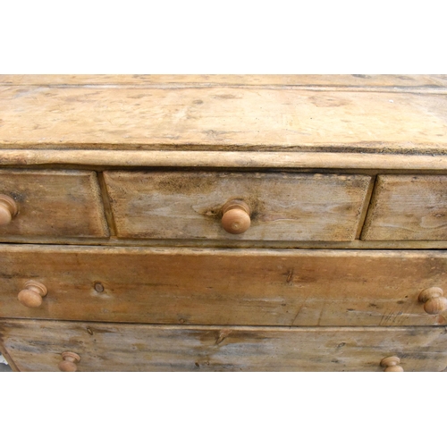 426 - An antique pine chest of three short over two long drawers with turned handles, standing on bun feet... 