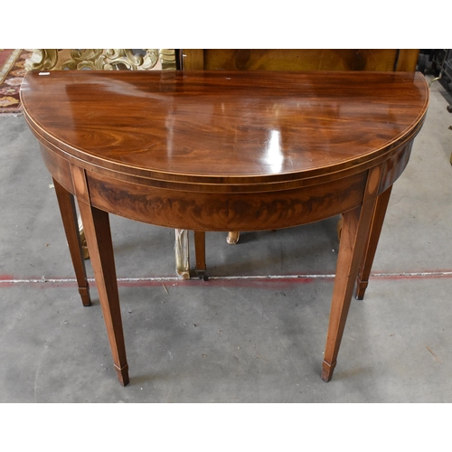 434 - A 19th century mahogany inlaid demi lune card table with folding base and lined top on tapering squa... 