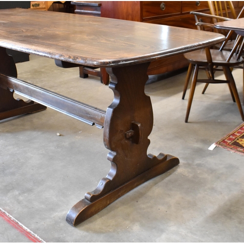 465 - An Ercol dark elm refectory style dining table with shaped supports and pegged stretcher, 182 cm x 8... 