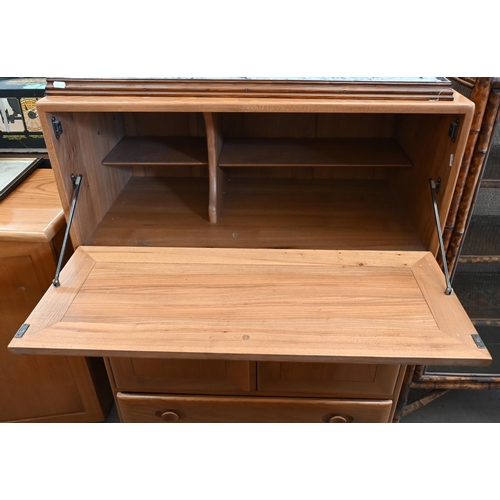 466 - An Ercol (model 469) Windsor elm serving cabinet with moulded and recessed handles on fall front pan... 