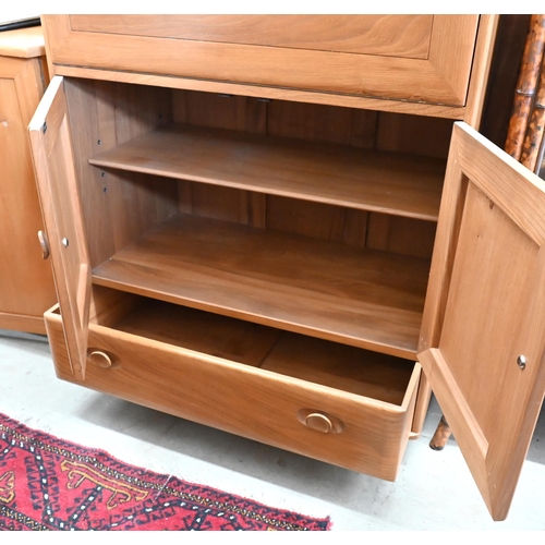 466 - An Ercol (model 469) Windsor elm serving cabinet with moulded and recessed handles on fall front pan... 