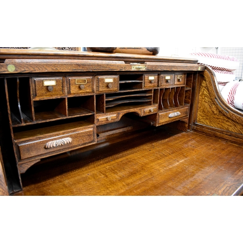 477 - A large late 19th century roll-top oak desk with sliding tambour panel enclosing fitted interior ove... 