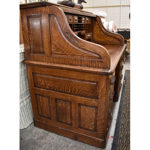 477 - A large late 19th century roll-top oak desk with sliding tambour panel enclosing fitted interior ove... 