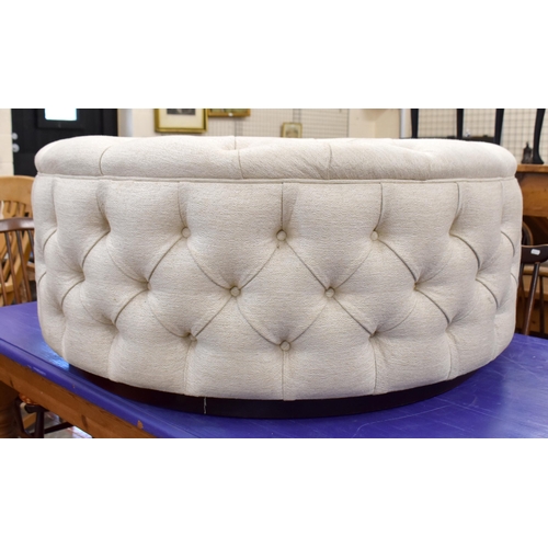 478 - A large circular button upholstered centre stool, ivory fabric upholstery on stained hardwood plinth... 