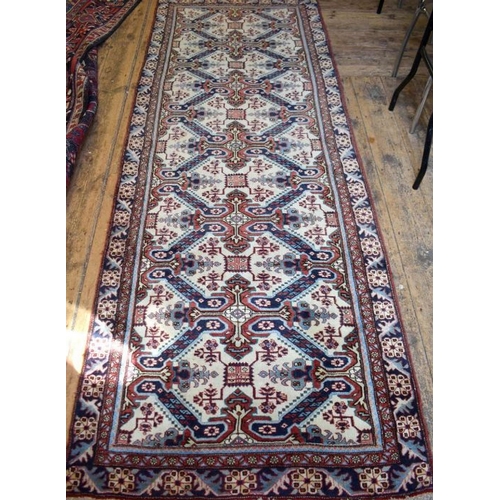 503 - A Persian Heriz runner, the linked geometric floral design on camel ground, 286 cm x 106 cm