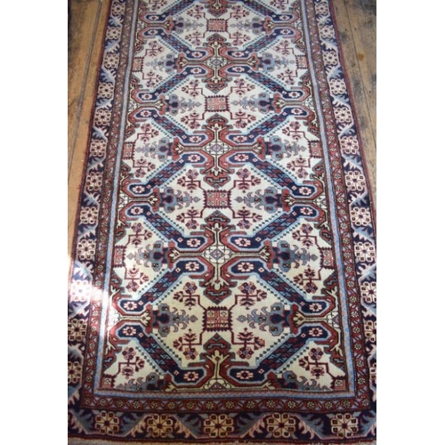 503 - A Persian Heriz runner, the linked geometric floral design on camel ground, 286 cm x 106 cm