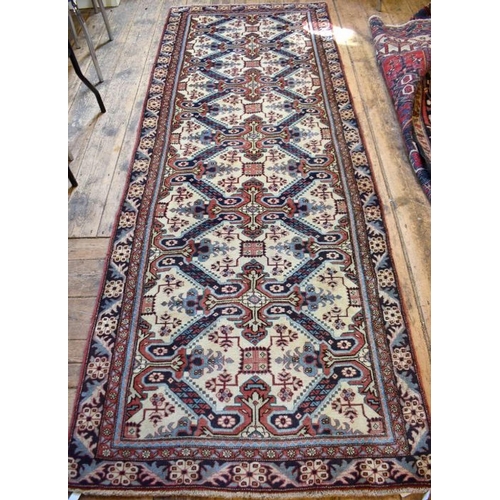 503 - A Persian Heriz runner, the linked geometric floral design on camel ground, 286 cm x 106 cm