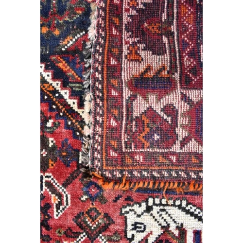 505 - An old Persian Shiraz carpet, the traditional red ground centred by a diamond lozenge, 268 x 166 cm