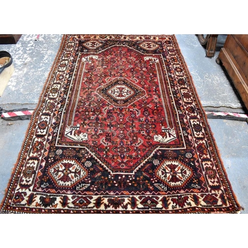 505 - An old Persian Shiraz carpet, the traditional red ground centred by a diamond lozenge, 268 x 166 cm