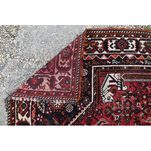 505 - An old Persian Shiraz carpet, the traditional red ground centred by a diamond lozenge, 268 x 166 cm