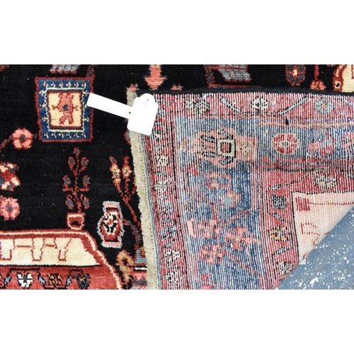 507 - A Persian Nahawand carpet, centred by a large ink black medallion within multi-coloured borders, 245... 