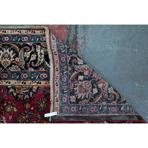 509 - A Persian Meshed carpet, the wine ground with geometric floral design incorporating the weavers sign... 