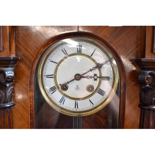 600 - Gustav Becker - a walnut cased German Vienna wall clock with foliate carved glazed case, enamelled b... 