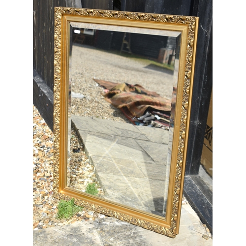 607 - A bevelled wall mirror in decorative foliate gilt frame