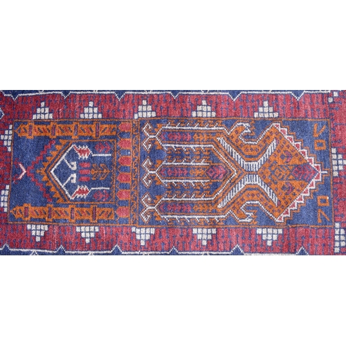 613 - A Persian Bokhara rug, gul design on brick ground, multi borders, 105 cm x 51 cm, to/w two Baluch na... 