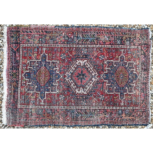 615 - A Persian Heriz rug, geometric medallions on red ground, navy border, 138 cm x 49 cm