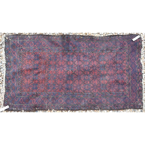 618 - A Persian Baluchi red ground rug with repeating geometric design, blue borders, 152 cm x 82 cm