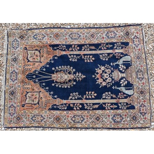 623 - An antique Persian hand-made Kashan rug, the washed camel field centred with a blue medallion, 195 c... 