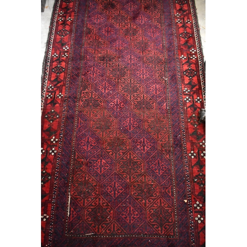 633 - A contemporary Belouch rug, the repeating geometric design on dark red ground, 190 cm x 95 cm