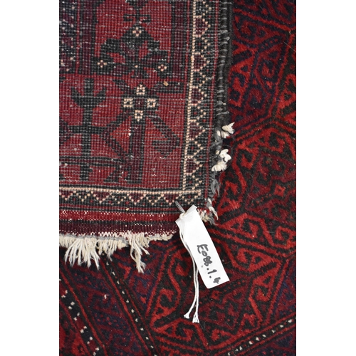 633 - A contemporary Belouch rug, the repeating geometric design on dark red ground, 190 cm x 95 cm