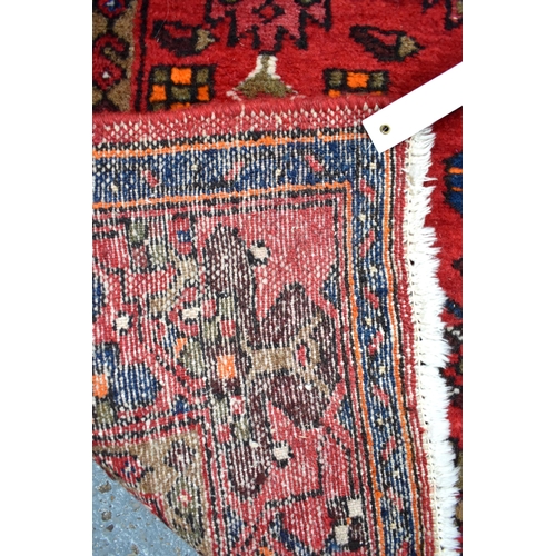 635 - A Persian Shiraz rug with dark medallion on red ground, 207 x 133 cm