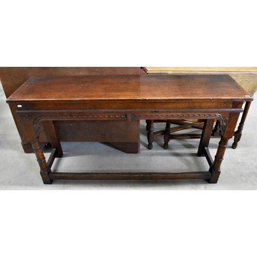 645 - An antique oak narrow console table with chip-carved frieze and turned supports united by stretchers... 