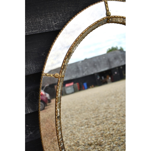 649 - Venetian style oval wall mirror with gilt floral embellished gilt metal edging, 105 x 70 cm