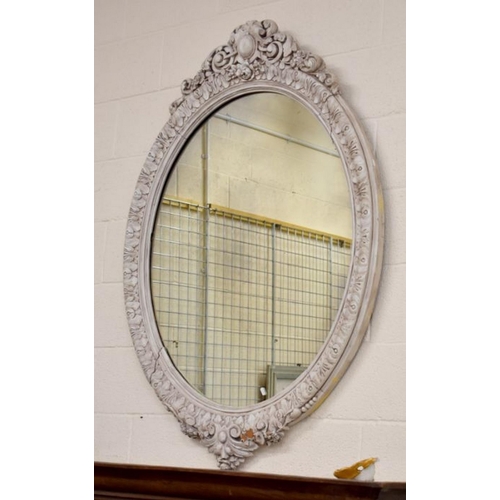 650 - A large antique oval wall mirror in decorative cream painted floral and foliate carved frame, 100 cm... 