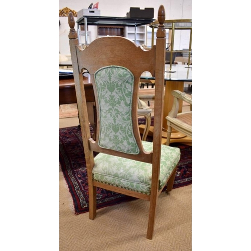 670 - An Arts and Crafts style floral carved oak nursing chair, green floral fabric back and seat, taperin... 