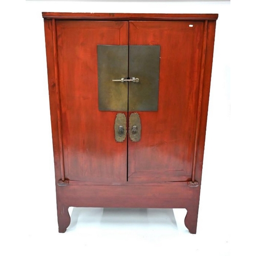 77 - An antique Chinese red lacquer Chinese cabinet with brass mounts, the pair of doors enclosing an int... 