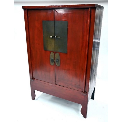 77 - An antique Chinese red lacquer Chinese cabinet with brass mounts, the pair of doors enclosing an int... 