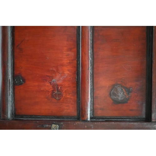 77 - An antique Chinese red lacquer Chinese cabinet with brass mounts, the pair of doors enclosing an int... 