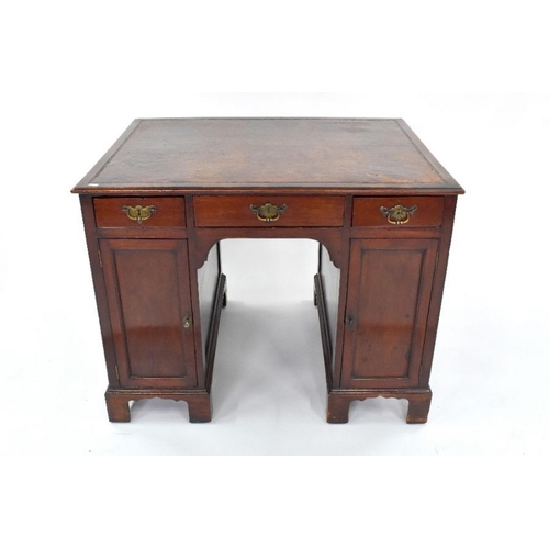 95 - A George III mahogany kneehole writing desk, the rectangular top with brown leather surface, over th... 