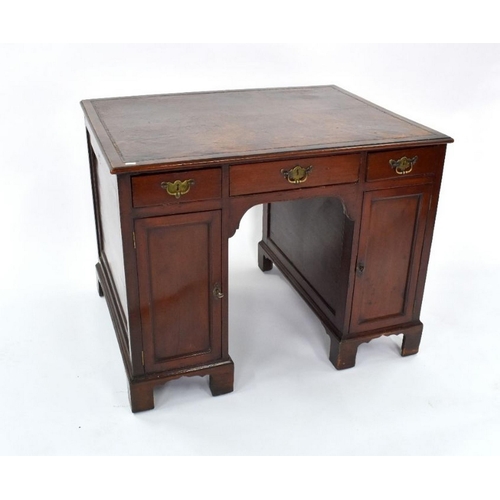 95 - A George III mahogany kneehole writing desk, the rectangular top with brown leather surface, over th... 